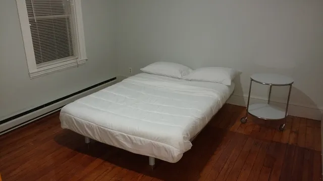 a bed sitting in a bedroom next to a window