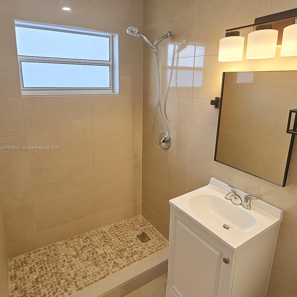 724 Northwest 3rd Court, Unit 2 Hallandale Beach, FL 33009 - Photo 3 of 6 a bathroom with a sink a toilet and shower