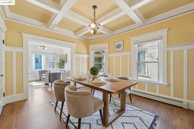 a dining room with wooden floor a chandelier a wooden table and chairs