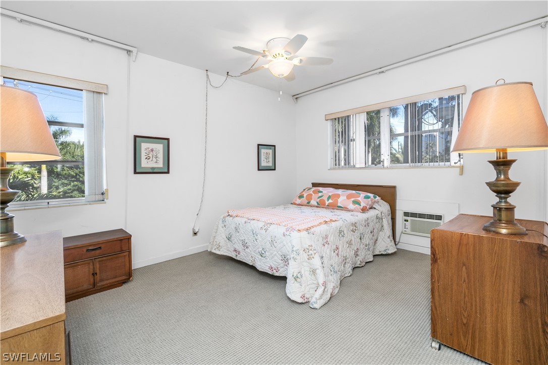2544 First Street, Unit 201 Fort Myers, FL 33901 - Photo 14 of 19 a bedroom with bed and a chandelier