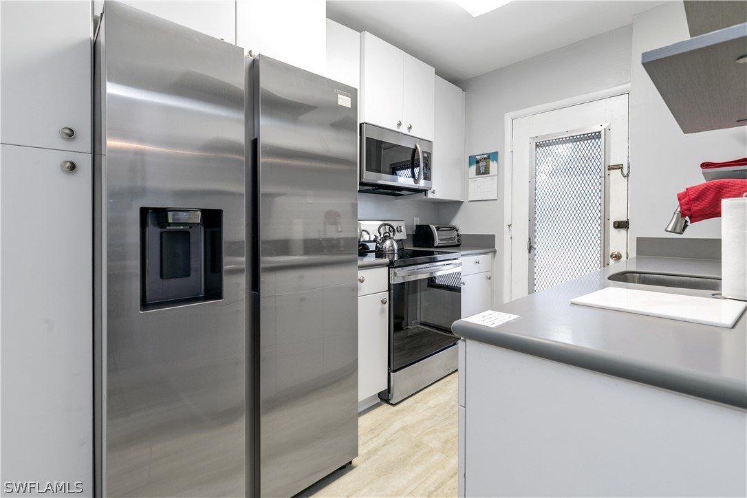 2544 First Street, Unit 201 Fort Myers, FL 33901 - Photo 4 of 19 a kitchen with stainless steel appliances granite countertop a refrigerator and a sink