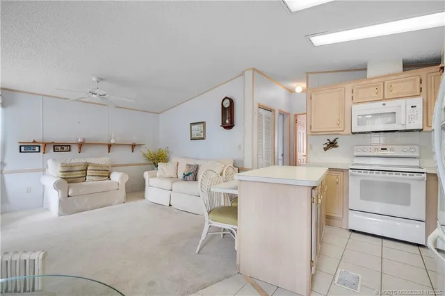 a kitchen that has a lot of white cabinets and stainless steel appliances