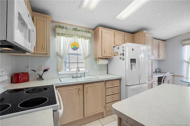 a kitchen with a sink a refrigerator and cabinets