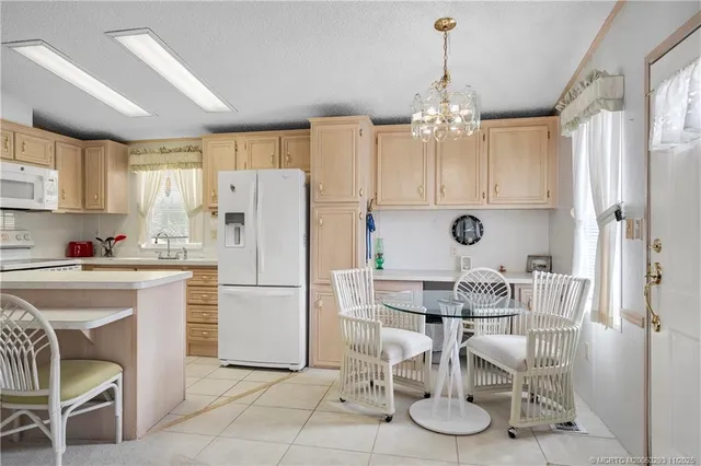 a kitchen with a dining table chairs appliances and cabinets