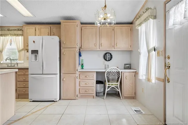 a white refrigerator freezer and a stove sitting inside of a kitchen