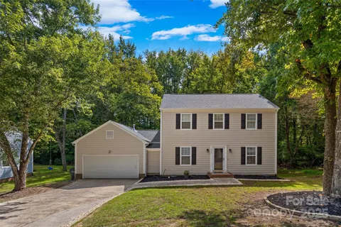 a front view of a house with a yard and trees