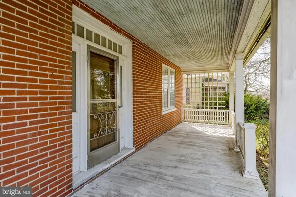 a view of a porch with a door and wooden floor