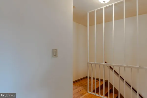 a view of staircase with railing and white walls