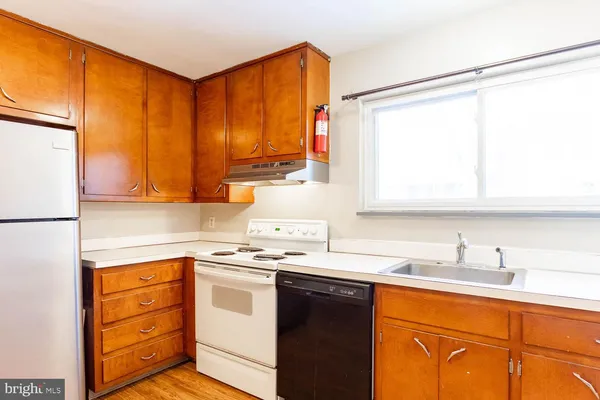 a kitchen with stainless steel appliances a sink cabinets and a window