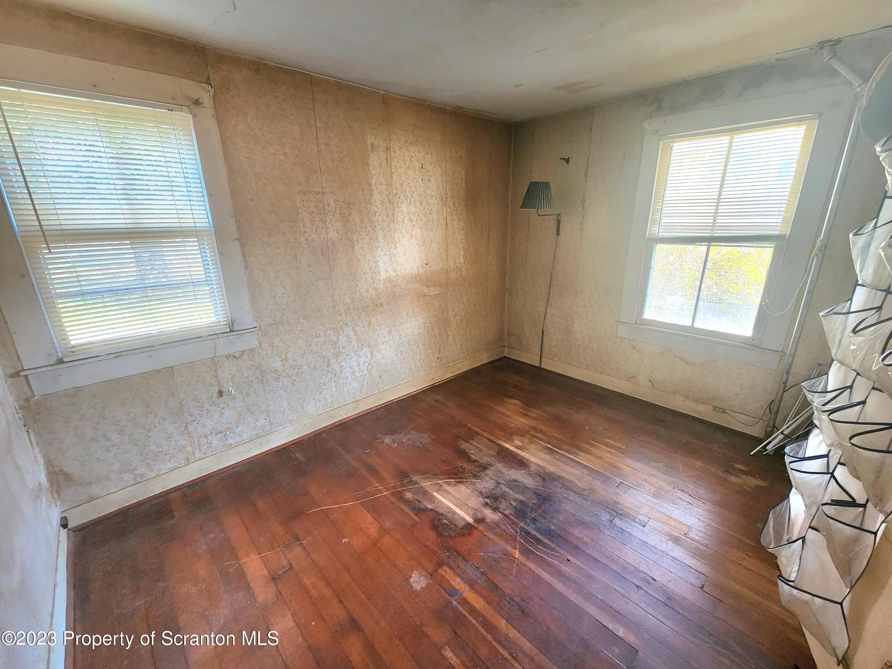 21 High Street Nicholson, PA 18446 - Photo 7 of 33 an empty room with wooden floor and windows