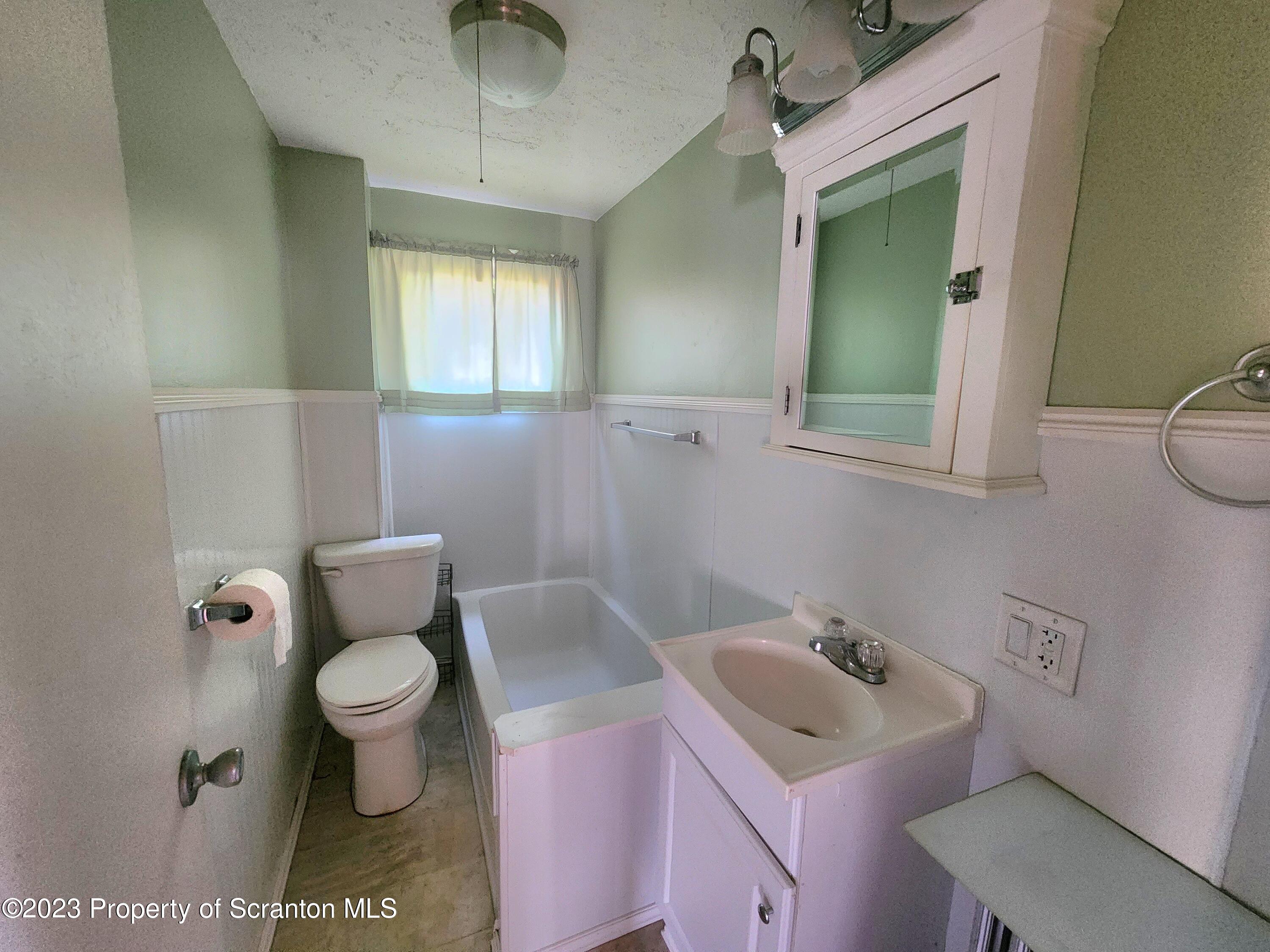 21 High Street Nicholson, PA 18446 - Photo 8 of 33 a bathroom with a toilet sink vanity and mirror