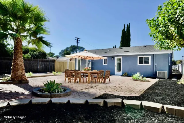 a view of a house with backyard and sitting area