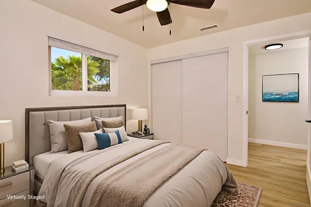 a view of a hallway with wooden floor and a bathroom