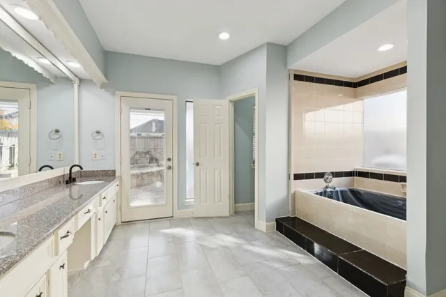a large white kitchen with a large window and stainless steel appliances
