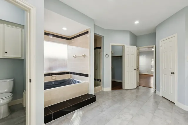 a bathroom with a tub and a view of bathroom