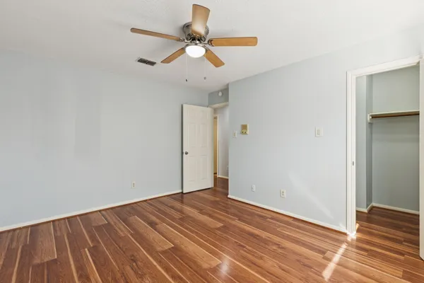 a view of room with wooden floor and ceiling fan