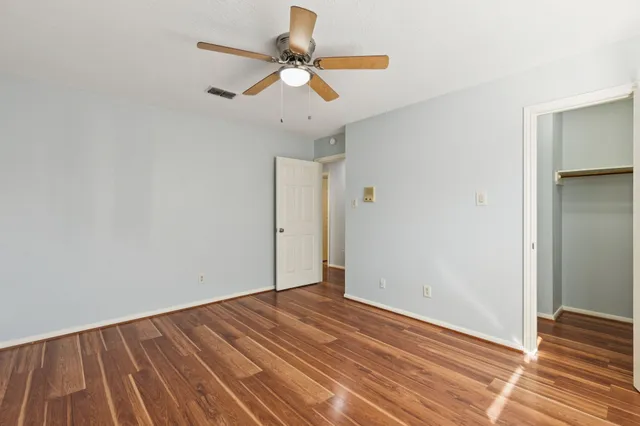 a view of room with wooden floor and ceiling fan