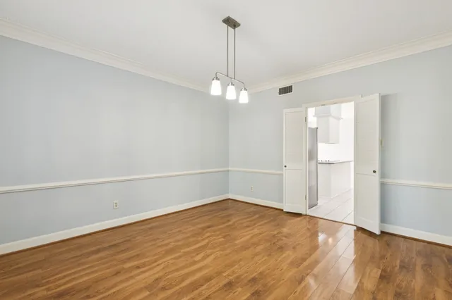 a view of a room with wooden floor and white walls