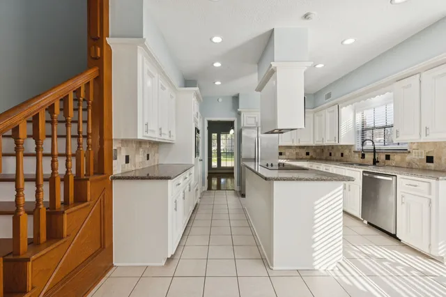 a kitchen with a sink window and cabinets