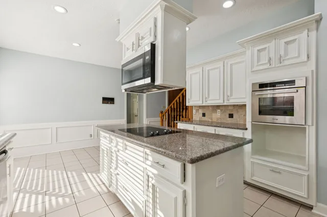 a kitchen with stainless steel appliances granite countertop a sink and a stove