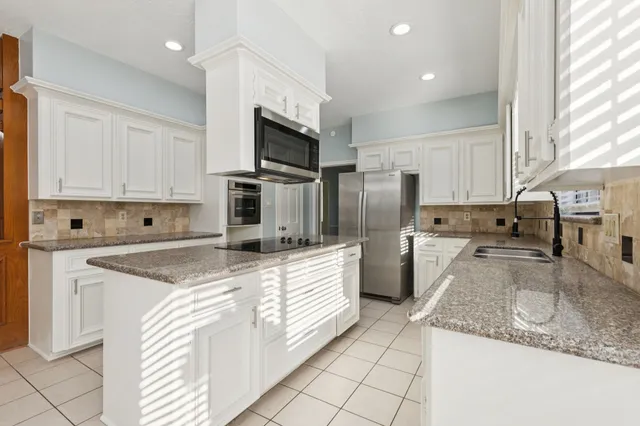 a kitchen with stainless steel appliances granite countertop a sink and a stove