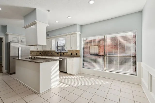 a kitchen with granite countertop a stove a sink and a refrigerator