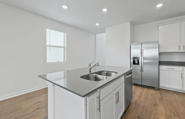 a kitchen with granite countertop a stove top oven a sink a counter space and cabinets