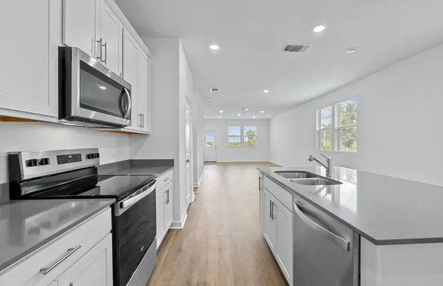 a kitchen with kitchen island a counter space a sink and appliances