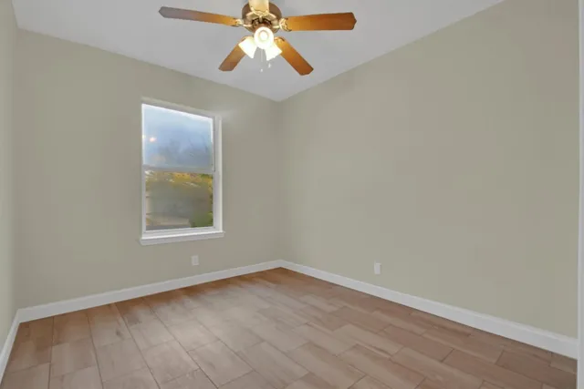 an empty room with a window and wooden floor
