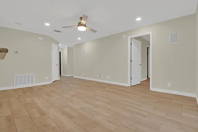 a view of an empty room with wooden floor