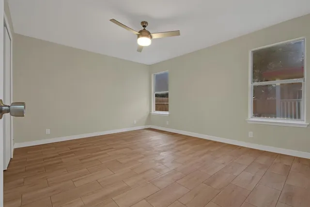 wooden floor in an empty room with a window