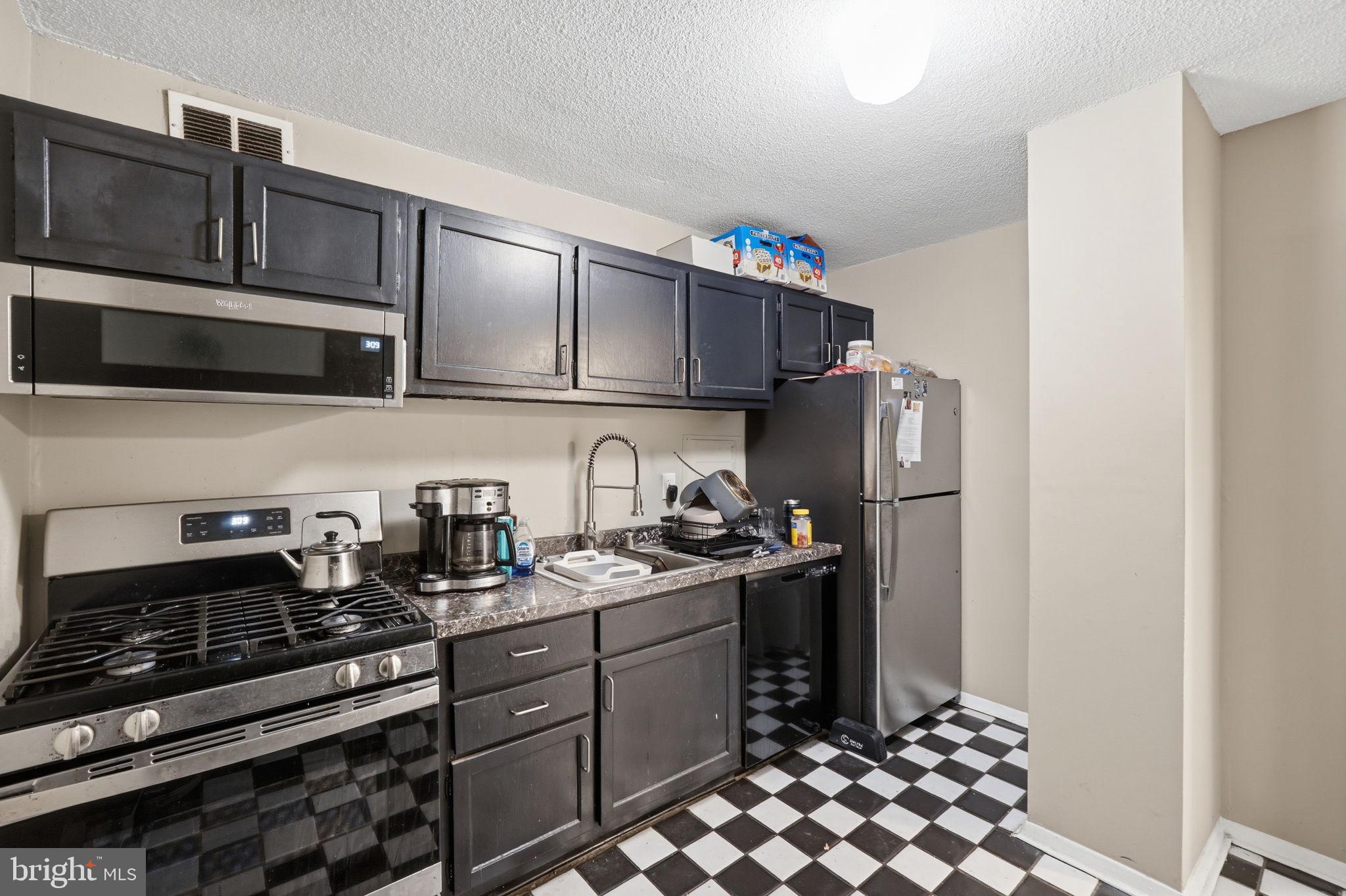 1836 Metzerott Road, Unit 904 Hyattsville, MD 20783 - Photo 6 of 37 a kitchen with stainless steel appliances granite countertop a refrigerator and a stove top oven