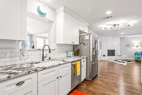 a kitchen with stainless steel appliances granite countertop a refrigerator and a stove top oven