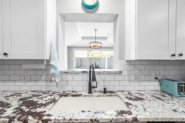 a kitchen with granite countertop a refrigerator stove top oven and sink