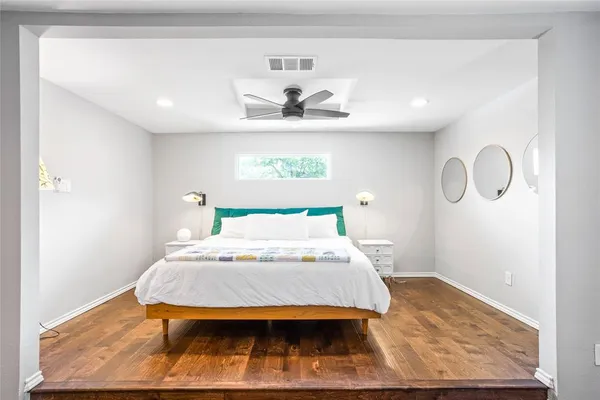 a bedroom with a bed and wooden floor