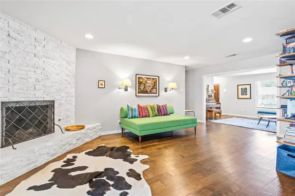 a living room with furniture a rug and a book shelf