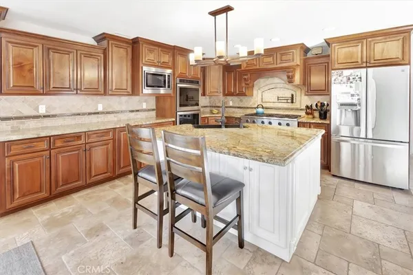 a kitchen with stainless steel appliances granite countertop a stove top oven a refrigerator a sink and dishwasher