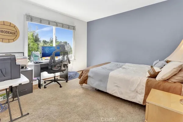 a bedroom with a bed chair and window