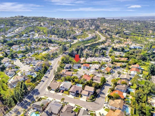 an aerial view of residential houses with outdoor space and trees