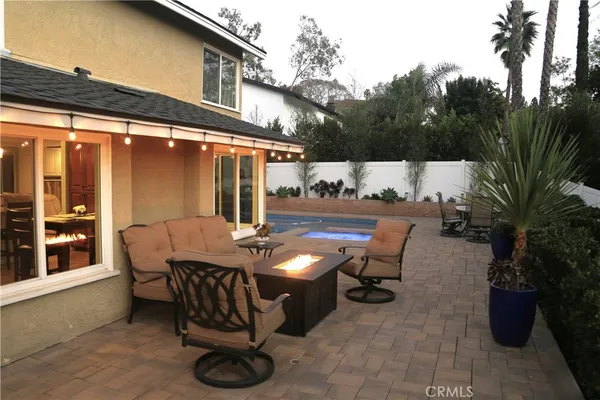 a view of a patio with table and chairs and floor to ceiling window