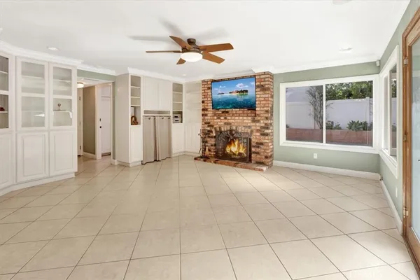 an empty room with windows and ceiling fan