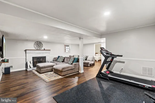 a living room with furniture gym equipment and a fireplace