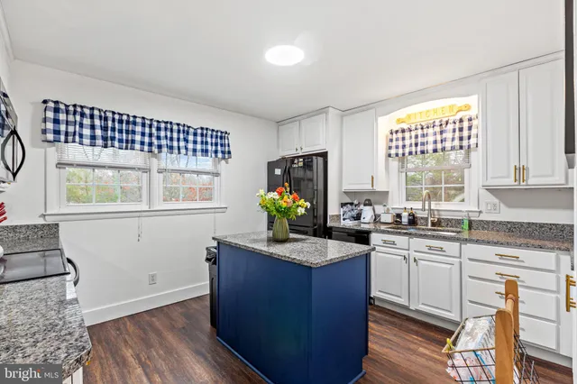 a kitchen with granite countertop wooden floors and sink