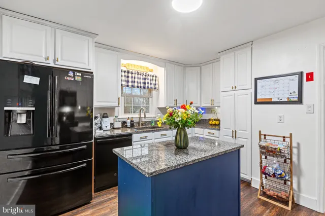 a kitchen with granite countertop a sink stainless steel appliances and cabinets