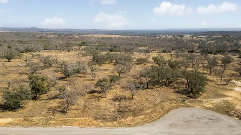 an aerial view of residential houses with outdoor space and trees