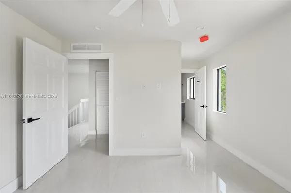 a view of a bedroom with a furniture and ceiling fan
