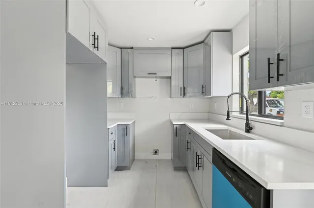 a kitchen with a sink a stove and cabinets