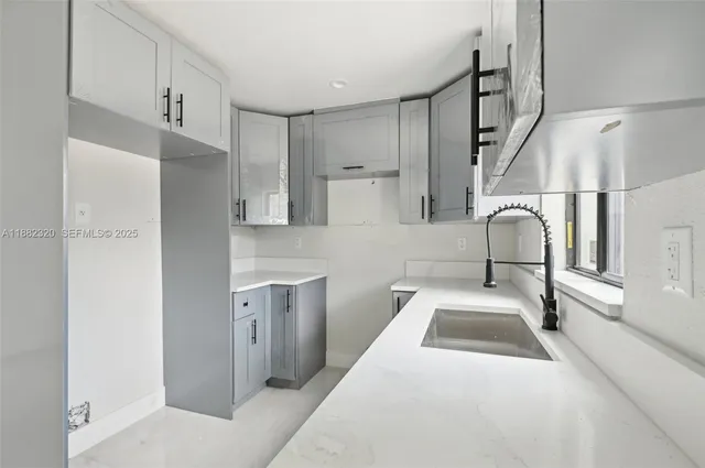 a bathroom with a sink and mirror with bathtub