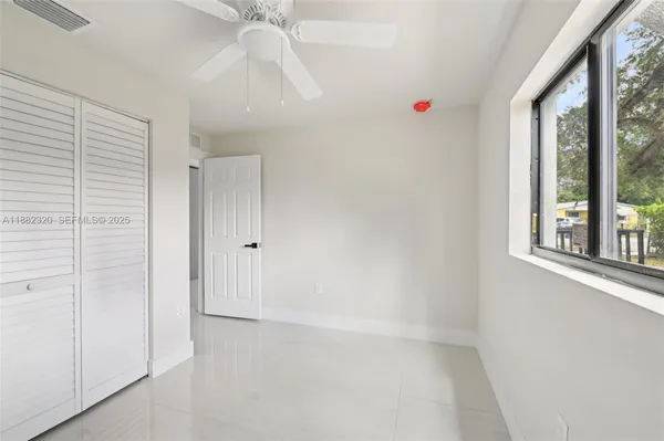 an empty room with windows and cabinet
