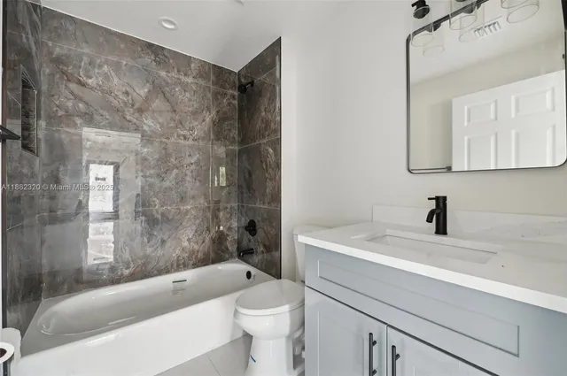 a bathroom with a sink a toilet and bathtub